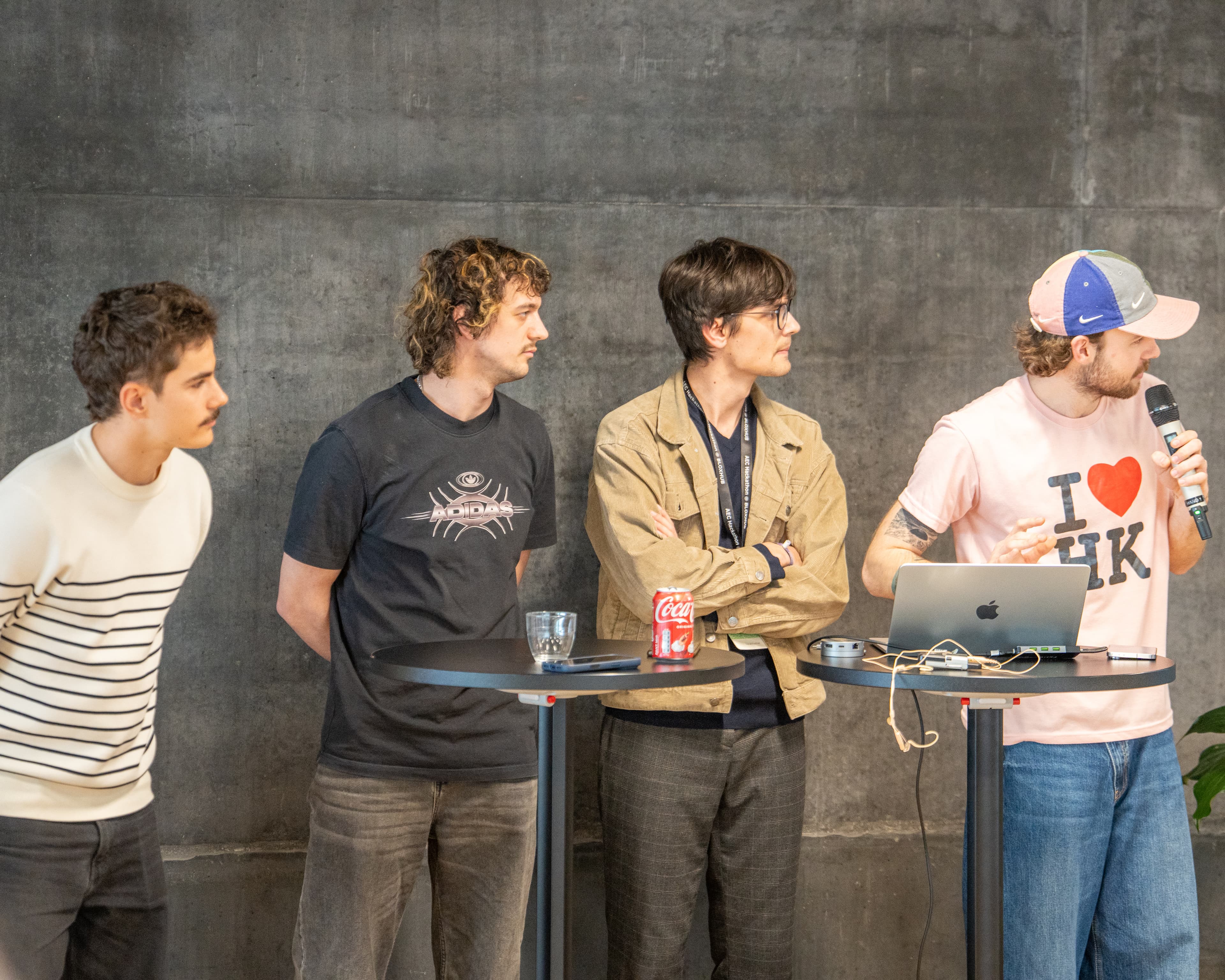 Team Klaudiush during the post-pitch Q&A — four teammates at tall tables, microphone being passed between them